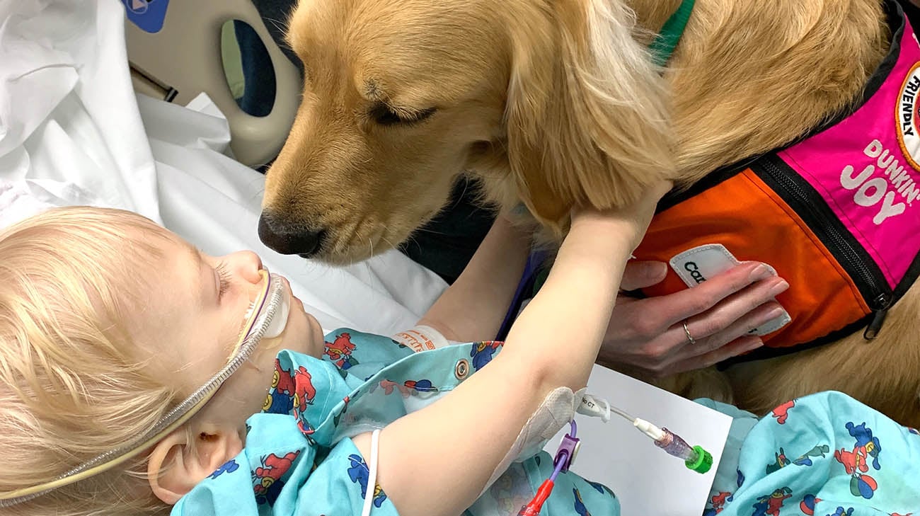 Jude with facility dog Trotter at Cleveland Clinic Children's. 